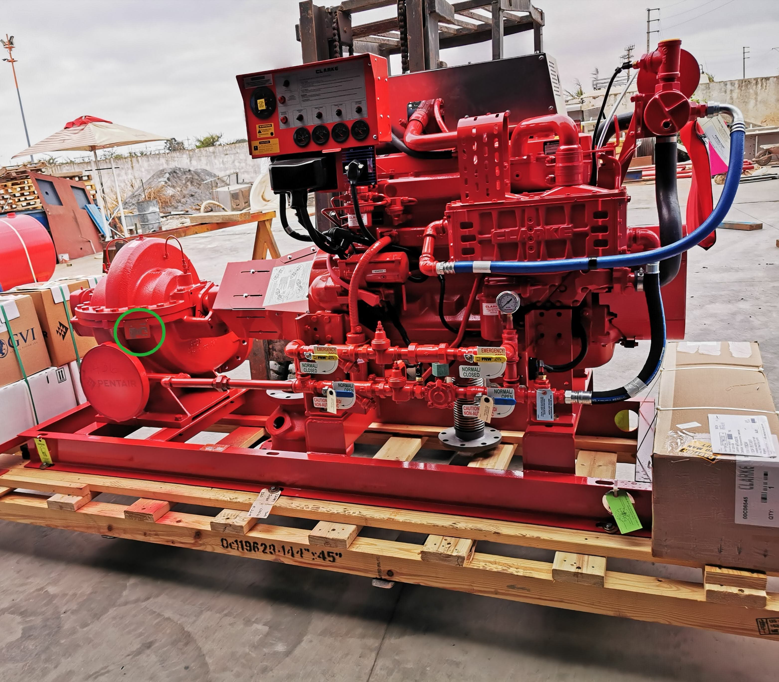 Pompe à incendie industrielle rouge avec moteur diesel et panneau de contrôle sur palette bois.